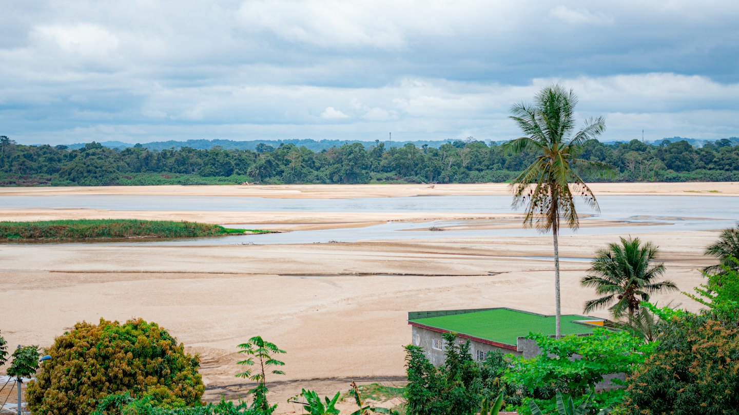 A wide river flows through a lush tropical rainforest landscape.