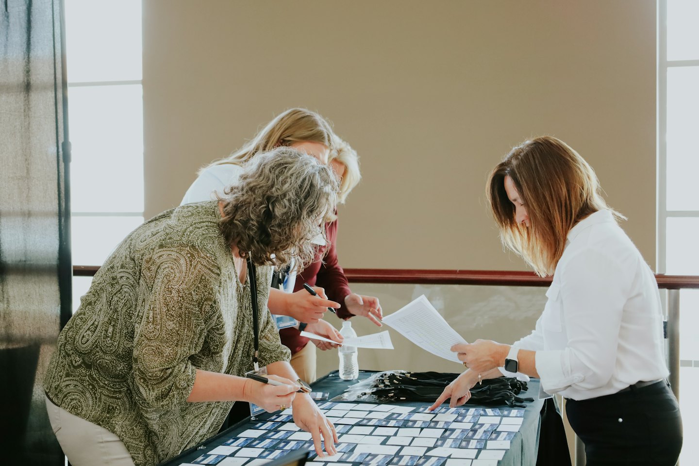 Three professionals staff a registration table at an event.